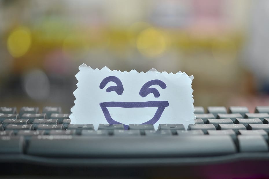 chief happiness officer per portare la felicità sul lavoro: postit con faccina sorridente sulla tastiera di un pc